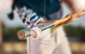 a teen baseball player hitting a ball