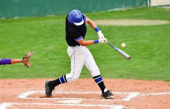 Baseball catcher and batter hitting a ball