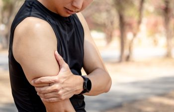 Bicep tendonitis or front arm muscle inflammation. Asian athlete man suffering from upper arm pain while doing outdoor exercise in the park. Sport injury concept